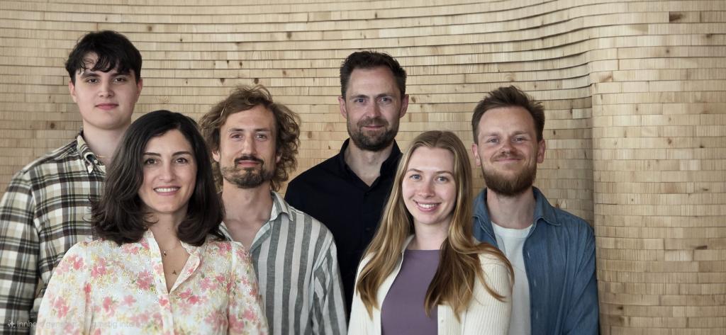 Bildet visere teamet som arbeider med Kunnskapsassistenten, gruppebildet er tatt på Deichman Bjørvika og avbildet fra venstre ser man: Olav Fosse, Asli Aydemir, Fredrik Danker Monsen, Benjamin David Brodie, Marie Berntsen, Simen Strøm Braaten