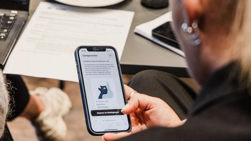 person som holder mobiltelefon der systemet kalt Casegeneratoren vises på skjermen