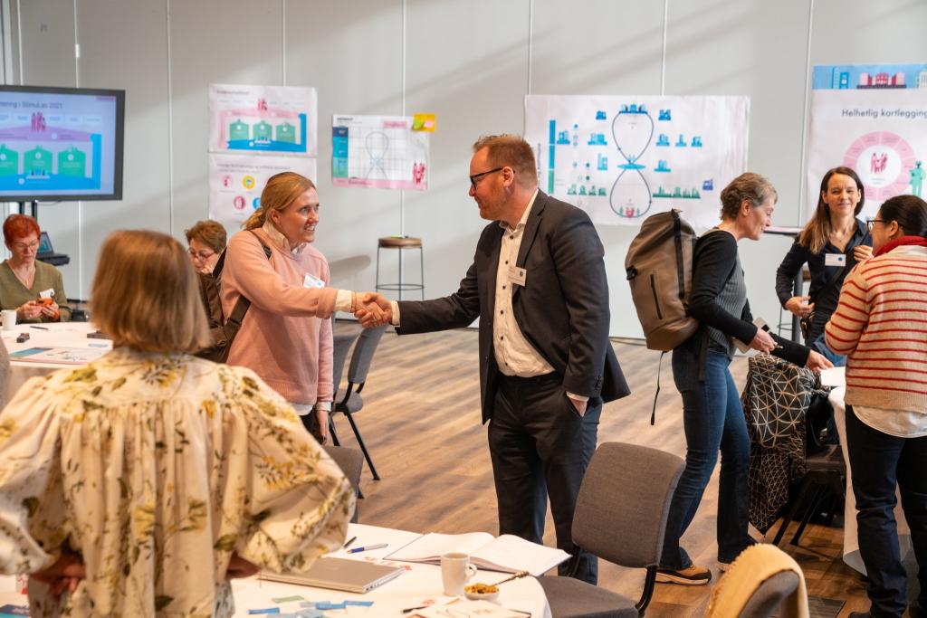 To personer som møtes og håndhilser under et møte