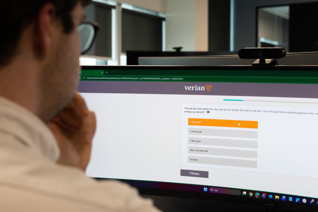 En mann som sitter på datamskin og fyller ut en undersøkelse.